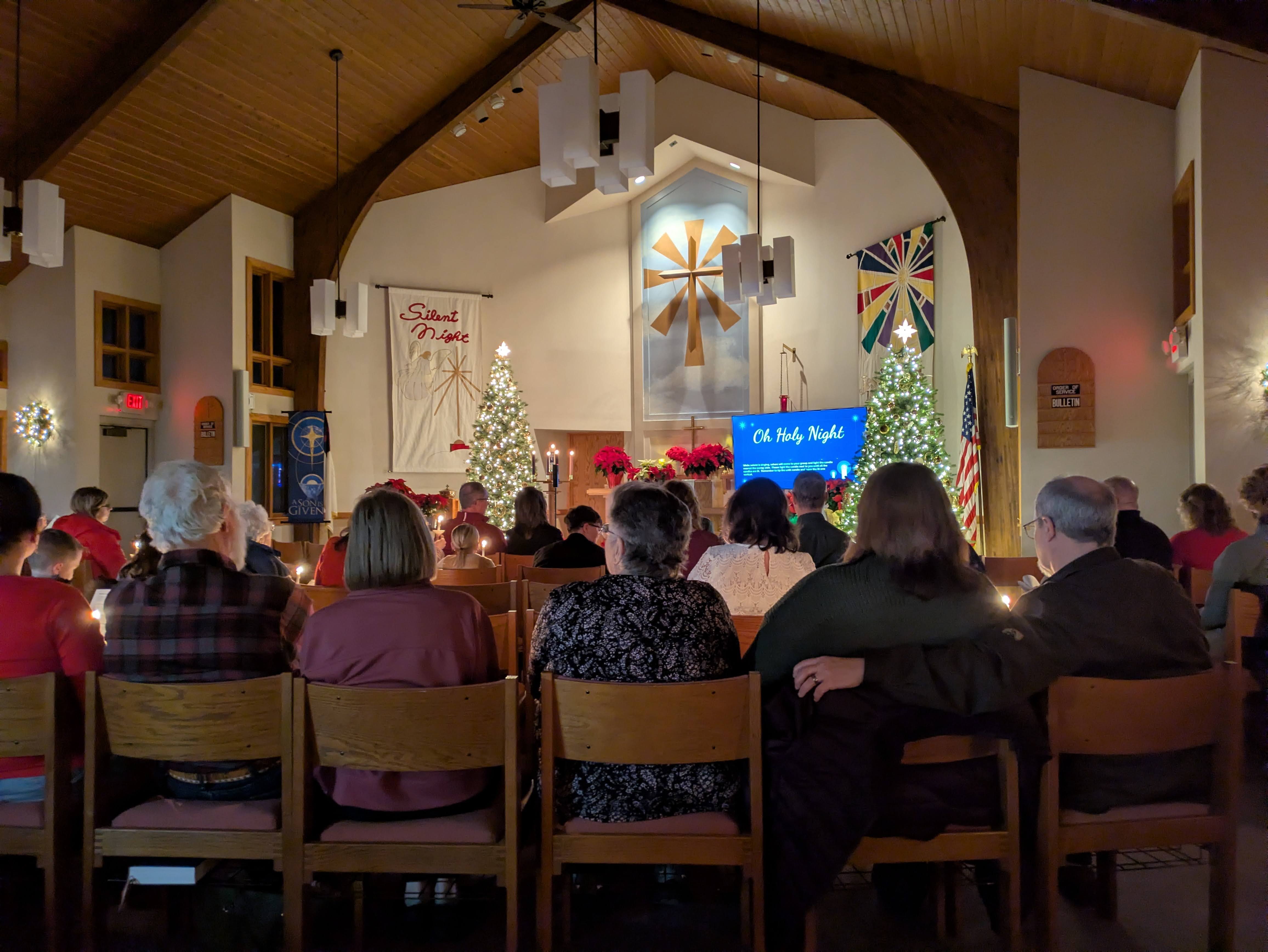 Congregation holding candles during a Christmas Eve candlelight service
