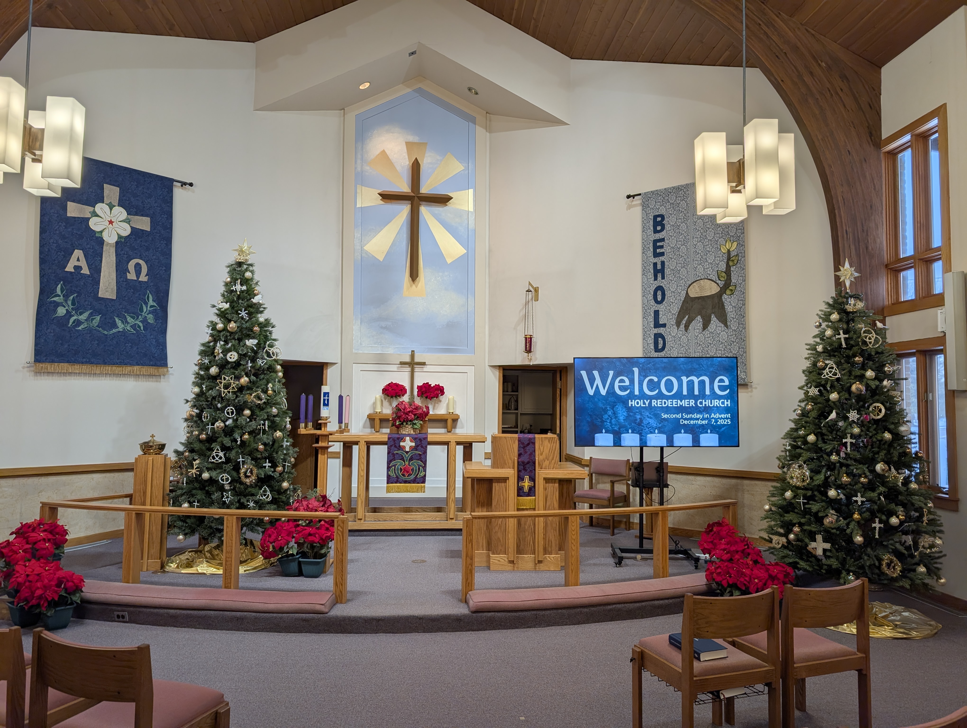 Sanctuary decorated for Christmas with Advent candles and a welcome screen